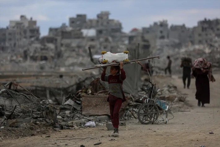 Cô gái Palestine mang theo đồ đạc trở về nhà ở thành phố Gaza sau khi lực lượng Israel rút quân. Đối với người dân Palestine, dù nhà cửa đã bị phá hủy, điều quan trọng nhất đối với họ là được trở về. Ảnh: Anadolu.