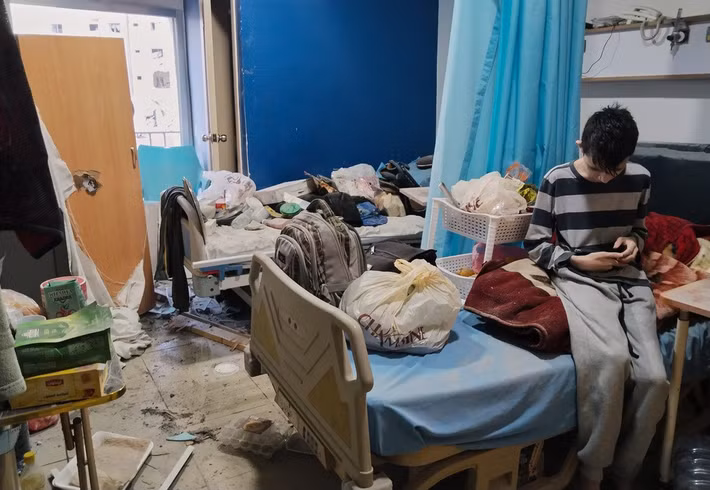 Một bé trai ngồi trong phòng bệnh tại Bệnh viện Jabal Amel bị hư hại trong các cuộc không kích của Israel. Ảnh: AP.