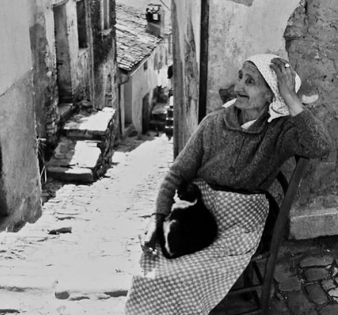 Cụ bà ngồi nghỉ ngơi trong con hẻm ở một làng quê tại Italy những năm 1960.