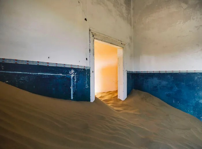 Những gia đình cuối cùng rời khỏi Kolmanskop vào năm 1956, khiến nơi này bị bỏ hoang. Nhiều ngôi nhà trong thị trấn sau đó bị cát "nuốt chửng". Ảnh: Bored Panda.