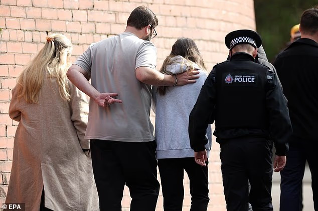 Người dân được cảnh sát dẫn đi qua khu vực xảy ra vụ tấn công khủng bố ở Manchester. Ảnh: EPA.