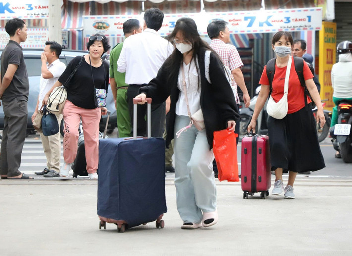 Những hành khách trong đợt trung chuyển bằng xe khách đầu tiên sau khi xuống xe đi vào ga Dĩ An để tiếp tục hành trình về ga Sài Gòn.