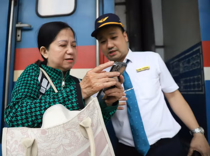 Nữ hành khách hỏi nhân viên ngành đường sắt vị trí toa tàu để thuận lợi di chuyển.