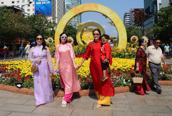 Dưới cái nắng ban trưa, nhiều người vẫn kiên nhẫn xếp hàng, chờ đến lượt để ghi lại bức hình ưng ý làm kỷ niệm cho mùa Tết năm nay.