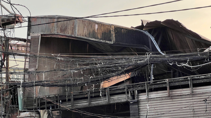 Cửa hàng đồ gỗ bị thiêu rụi, mái tôn đổ sập sau vụ cháy.