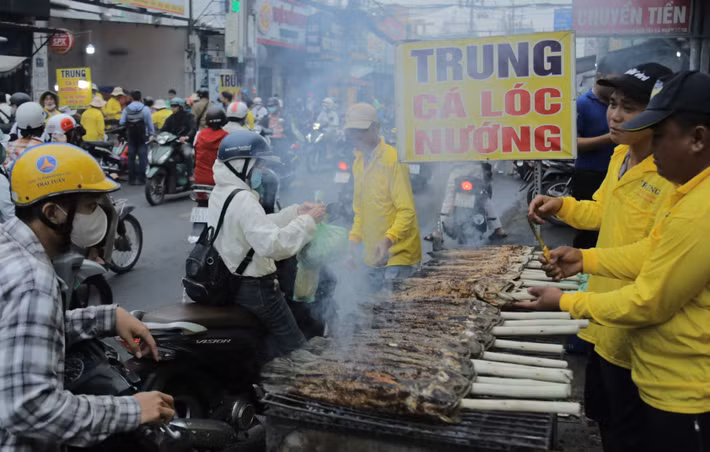 Người mua tấp nập ra vào các điểm bán cá lóc nướng trên đường Tân Kỳ Tân Quý.