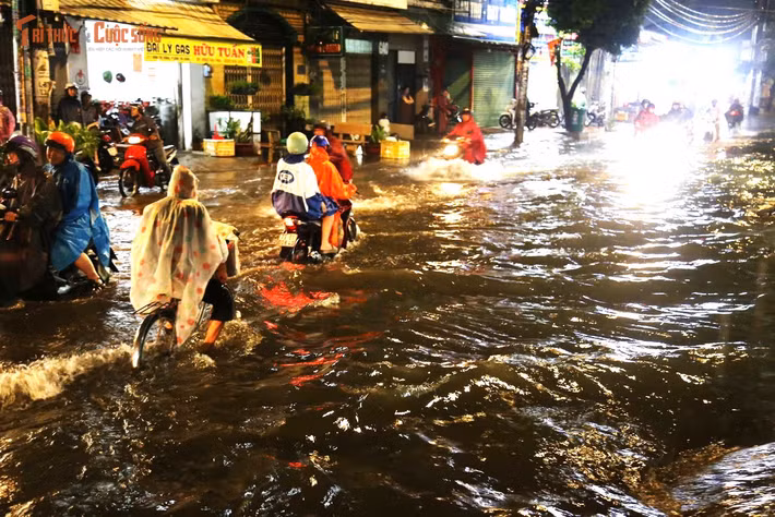 Người dân gồng mình đẩy xe chết máy trên đường Bình Trị Đông trong cơn mưa ngập tối 30/5. Nhiều người phải dắt xe hàng trăm mét mới tìm được nơi khô ráo để kiểm tra phương tiện.