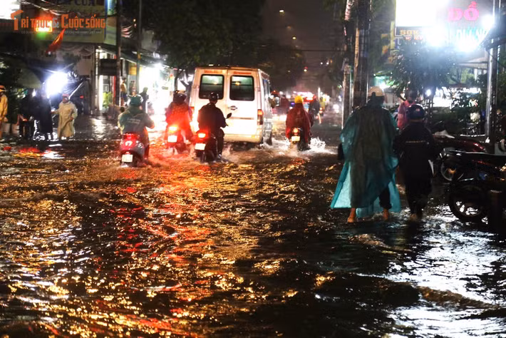 Đến khuya cùng ngày, nước vẫn còn ngập trên đường Bình Trị Đông, nhiều phương tiện phải di chuyển chậm để tránh chết máy.