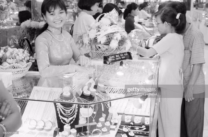 Cô bán hàng tươi cười tại tiệm kim hoàn nằm trong một trung tâm thương mại.