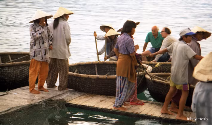 Hai ông khách Tây ngồi trên chiếc thuyền thúng của ngư dân địa phương.