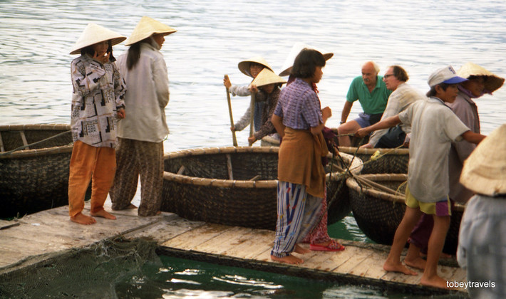 Hai ông khách Tây ngồi trên chiếc thuyền thúng của ngư dân địa phương.