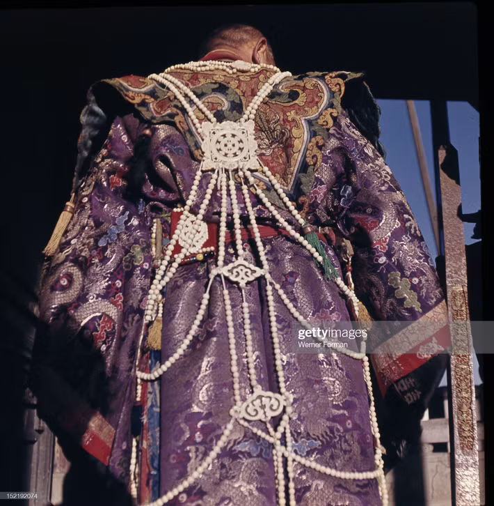 Vị thầy tế mặc trang phục lộng lẫy với áo choàng thổ cẩm gắn nhiều đồ trang sức.