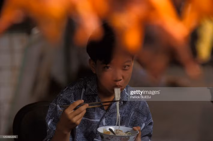 Bé trai thưởng thức phở sáng ở Sài Gòn.