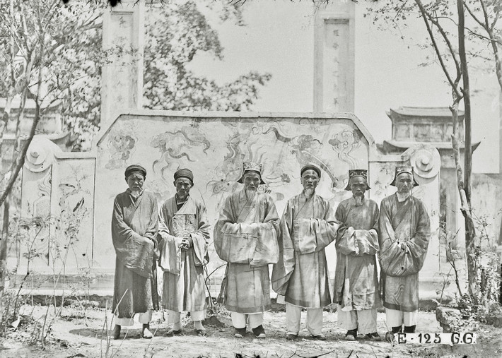 Các quan chức chụp ảnh kỷ niệm trước bức bình phong của đền.