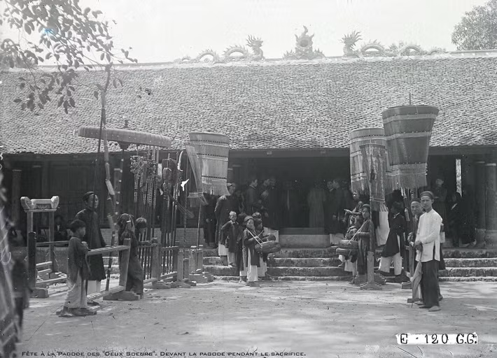 Khung cảnh ở sân đền. Trong điện thờ, các vị chức sắc đang làm lễ trước bàn thờ.