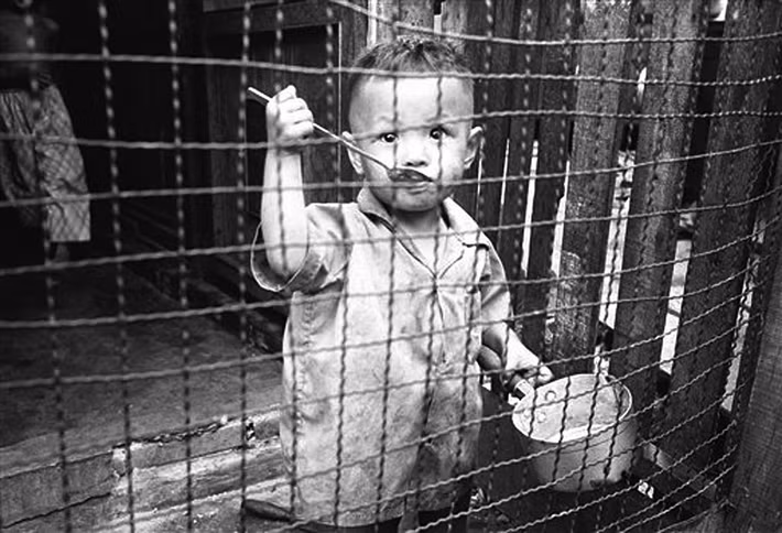 Em bé sau song sắt chuồng gà.