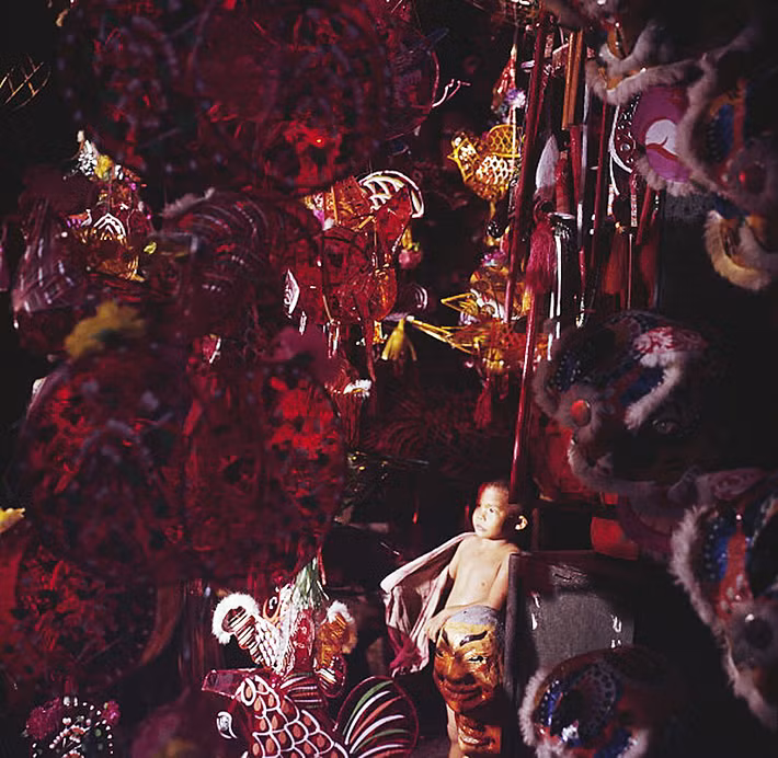 Một bé trai trong cửa hàng bán đồ chơi Trung thu ở Chợ Lớn năm 1961. Ảnh: Jack Garofalo.