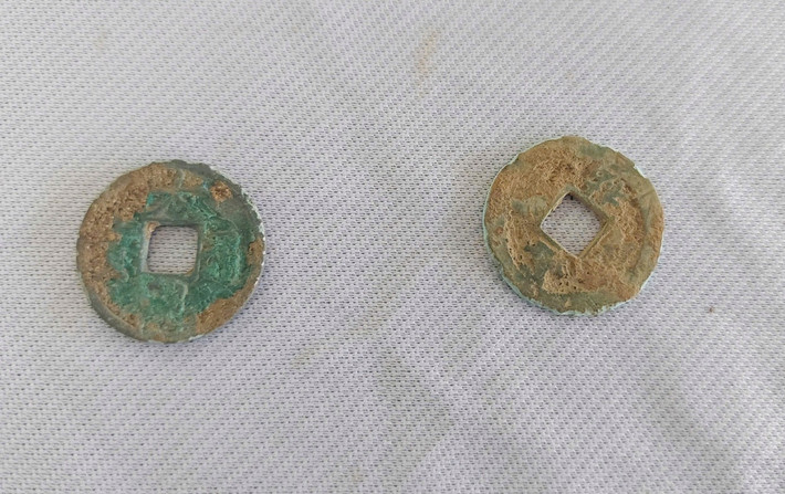 Hiện vật gồm hai nhóm chính: đất nung (gạch, ngói, gốm gia dụng) và kim loại, trong đó nổi bật là hai đồng tiền thời Tống, cho thấy dấu ấn giao lưu văn hóa. Ảnh: Trương Định / Báo Tiền Phong.