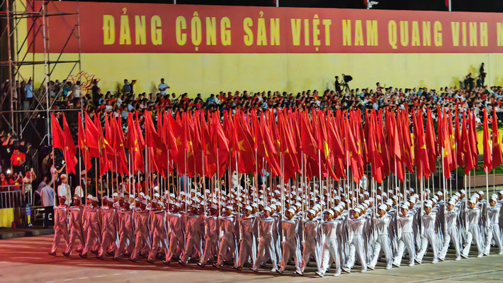 Giữa không gian thiêng liêng ấy, lá quốc kỳ đỏ thắm tung bay kiêu hãnh, gợi nhắc về lịch sử đấu tranh bất khuất và khát vọng vươn lên của đất nước.