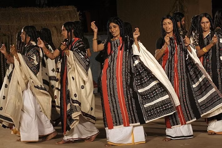  Trang phục thêu tay nổi bật. Trang phục truyền thống của người Toda là tấm choàng trắng với hoa văn đỏ và đen được thêu thủ công, mang tính biểu tượng cao và thường xuất hiện trong các dịp lễ nghi quan trọng. Ảnh: Pinterest.