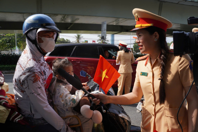 Phát nước suối, khăn lạnh miễn phí và tuyên truyền cho người dân chấp hành nghiêm các quy định của pháp luật khi tham gia giao thông (ảnh: H.G)