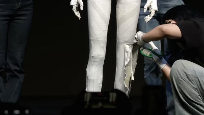 CEO XPeng, ông He Xiaopeng, đã mở khóa trang phục và cắt lớp bọc để lộ cấu trúc cơ khí bên trong.