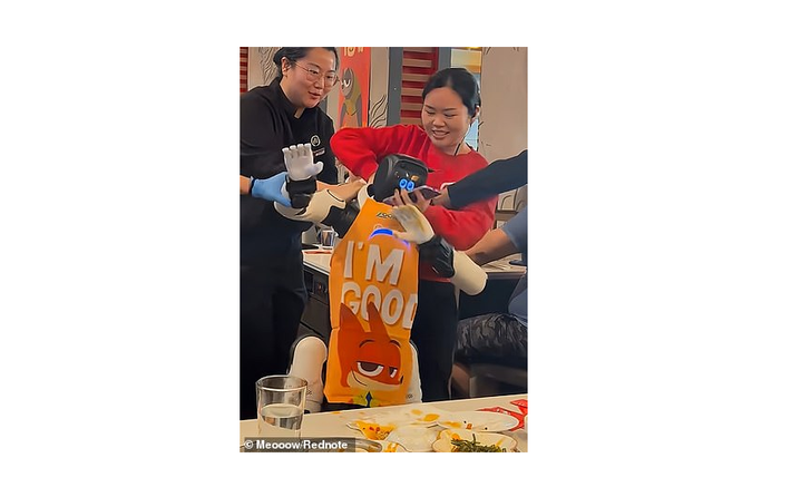 Chiếc tạp dề màu cam với dòng chữ “Tôi ổn” càng khiến tình huống trở nên trớ trêu và thu hút sự chú ý trên mạng xã hội.