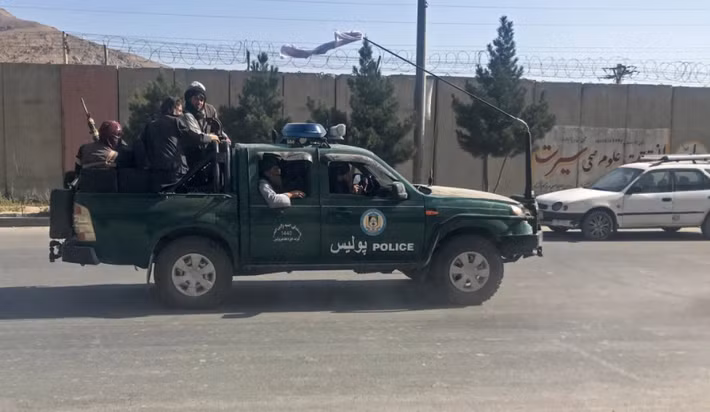 Các tay súng Taliban trên một chiếc xe cảnh sát ở Kabul.