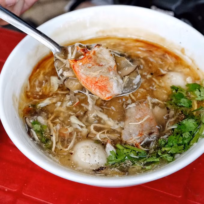Nhiều người thích ăn thêm óc heo hay trứng bắc thảo chung với súp. Súp cua có mặt ở mọi nẻo đường, từ các quán tên tuổi đến các xe hàng rong. Ảnh: Ivivu.
