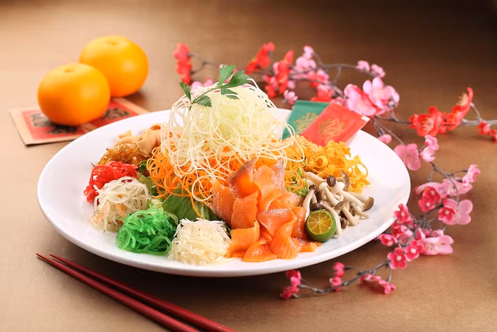 Gỏi Yu Sheng: Người Singapore có phong tục ăn món Yu Sheng trong năm mới với niềm tin sẽ được may mắn, tốt lành. Đây là món gỏi làm từ 27 nguyên liệu như cá hồi, các loại rau, củ, nhiều loại nước sốt và gia vị.