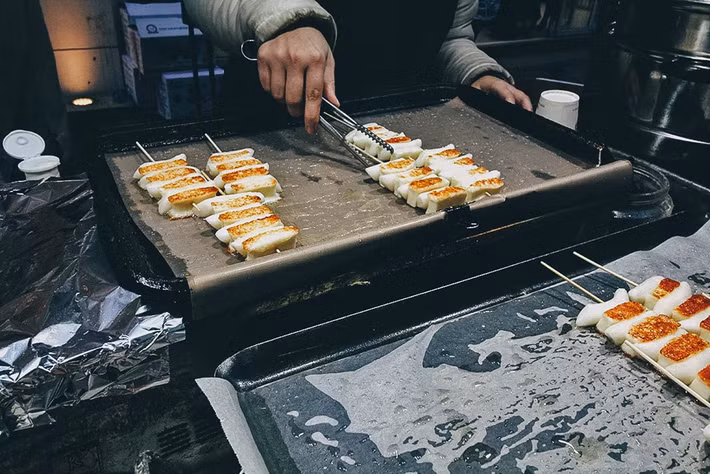 Bánh gạo nướng phô mai (Tokbokki): Bánh gạo mùa thu ở Hàn Quốc được làm từ gạo mới rất dẻo và thơm, được phủ lên trên một lớp phô mai béo ngậy sau đó nướng trên than hồng cho tan chảy. Món ăn nóng hổi này rất phù hợp để ăn trong tiết trời se lạnh của mùa thu Hàn Quốc. 