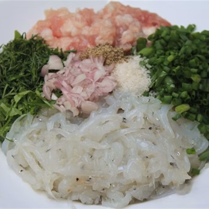 3. Chả cá ngần. Nguyên liệu: Cá ngần, thịt băm, trứng gà, hành khô, hành răm, thì là, lá lốt, gia vị. Cá ngần rửa sạch, để ráo nước. Hành, răm, thì là, lá lốt rửa sạch, thái nhỏ. Cho cá ngần vào bát tô trộn cùng với thịt băm nhỏ, trứng gà, tiêu, bột nêm, hành răm băm nhỏ. Ảnh: Cooky.vn.