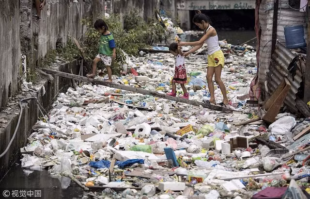 Trong ảnh là một đoạn của dòng sông rác chảy qua khu ổ chuột thuộc Manila, Philippines. Người dân sống tại khu vực này đã quá quen với cảnh tượng dòng sông ngập rác, bốc mùi hôi thối quanh năm.