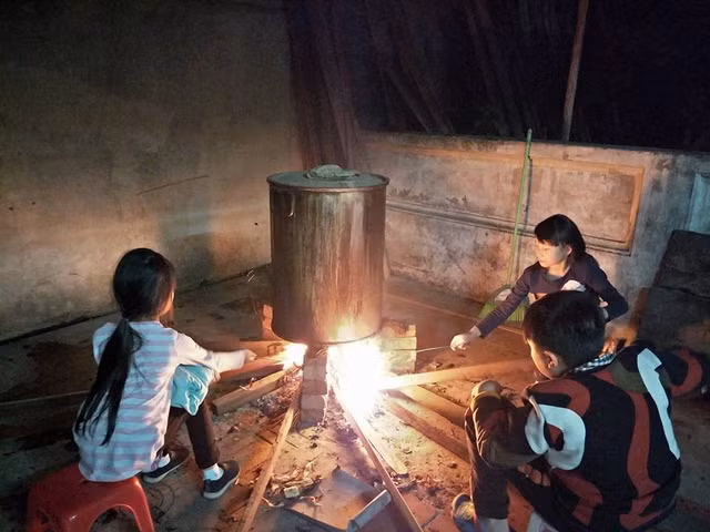 Đám trẻ con trong nhà háo hức ngồi canh bánh chưng. Việc gói bánh chưng đã giúp tình cảm gia đình thêm gắn kết, là cách thiết thực để giáo dục truyền thống gia đình cho các thế hệ sau.