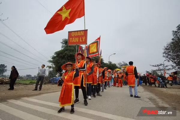 Được biết, mỗi năm người dân trong làng lại chọn ra những người cao tuổi xứng đáng để vào vai “vua, chúa” và 4 vị quan tứ trụ triều đình. Tất cả phải khỏe mạnh; còn đủ song toàn cụ ông, cụ bà; có đức độ và có uy tín trong dân chúng. Trong ảnh, trước khi màn rước “Vua, chúa sống” là lễ khênh kiệu từ đình làng về đền Sái với màn quay kiệu hừng hực khí thế và vui nhộn. Ảnh: Tường Bách.