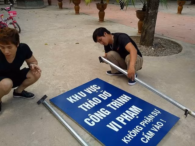 Ghi nhận của PV Tiền Phong vào sáng 30/3 cho thấy, hàng trăm công nhân cùng thiết bị máy móc đã được huy động để phá dỡ công trình sai phép. Ngoài ra, lực lượng chức năng lập chốt phong toả khu vực Tràng An cổ để đảm bảo an toàn cho việc phá dỡ. Trong ảnh: Cắm biển phong toả hiện trường để đảm bảo an toàn cho việc phá dỡ.