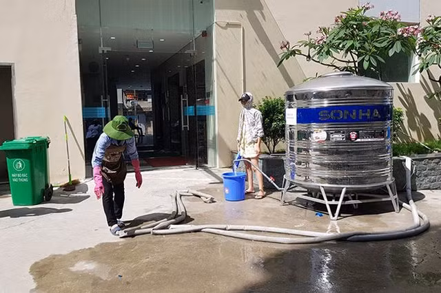 Cư dân Khu chung cư Xuân Mai Riverside "đội nắng" xuống sản lấy nước sạch về dùng.