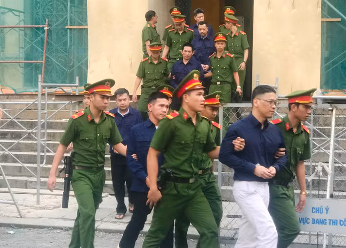 Các bị cáo được lực lượng Cảnh sát bảo vệ, hỗ trợ tư pháp đưa ra xe trở về trại tạm giam sau phiên tòa ngày 8/1.
