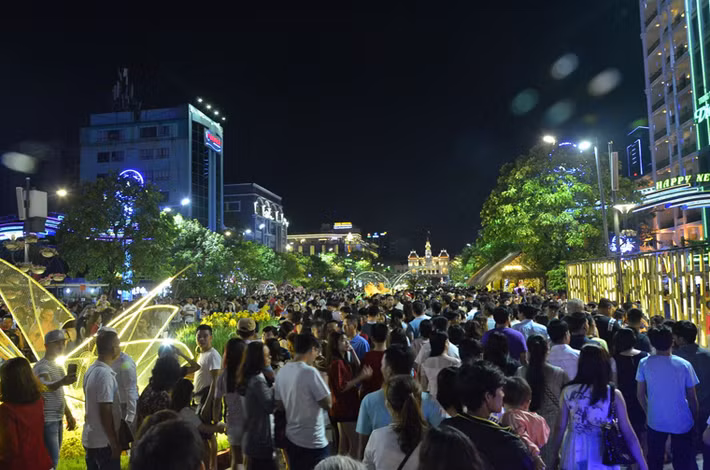 Khu vực phố đi bộ, đường hoa Nguyễn Huệ và công viên hướng ra sông Sài Gòn gần như chật ních người. Các bạn trẻ đến đây từ khá sớm chờ xem pháo hoa.