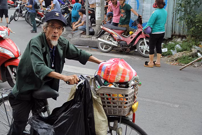 Một cụ già bán vé số hớn hở sau khi được nhận phần quà của hộ kinh doanh ở Chợ Lớn sau lễ cúng cô hồn rằm tháng 7 âm lịch. 