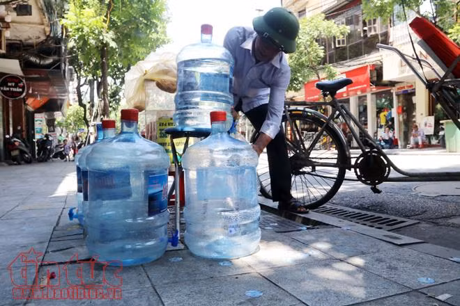 Mới từ sáng đên 11 giờ trưa, một gia đình ở 36 Hàng Bông tặng nước uống miễn phí cho người đi đường đã dùng hết 5 bình nước.