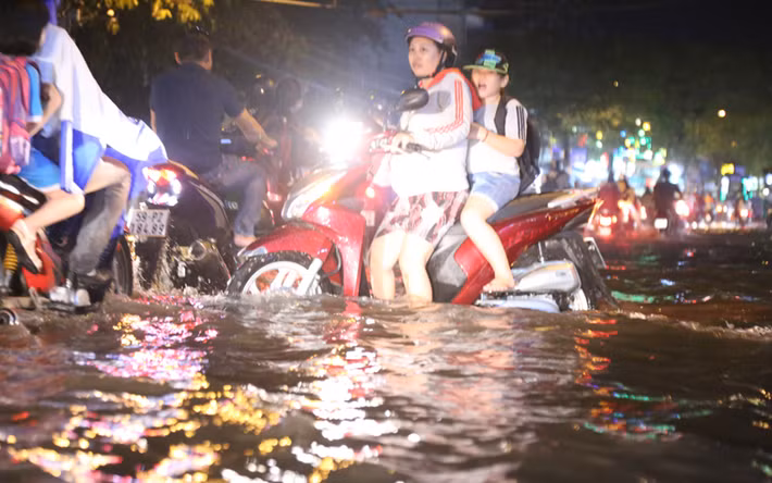 Nhiều em học sinh đi học về rất vất vả, có em bị ướt hết quần áo, tập sách... vì bị ngã xuống đường ngập nước.