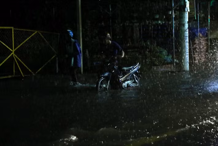 Lầm lũi dưới mưa giữa đêm khuya.
