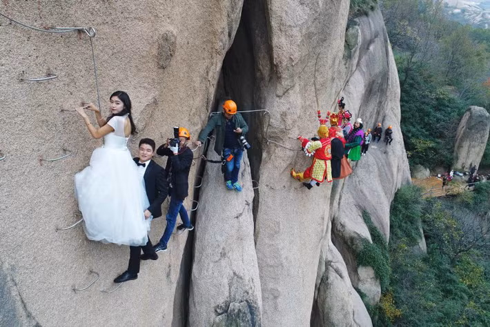 Ê-kíp chụp ảnh cưới gồm hàng chục người khá vất vả để ghi lại khoảnh khắc đẹp cho cô dâu, chú rể ở độ cao chóng mặt.