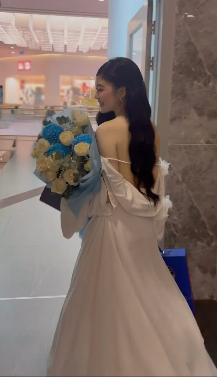 Váy trắng hở lưng với chi tiết nơ lớn phía sau cho thấy lựa chọn thời trang gợi cảm của Lọ Lem. Cô để tóc đen dài buông tự nhiên, hạn chế trang sức. Lối trang điểm nhẹ cùng làn da sáng giúp tổng thể vẫn giữ nét trẻ trung. (Ảnh: FB Mai Thảo Linh)
