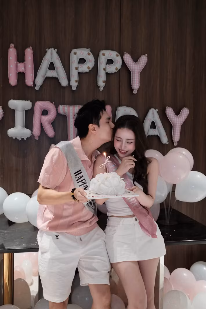 Trước đó, trong một bữa tiệc sinh nhật, Việt Anh và Quỳnh Nga cùng diện trang phục tông hồng - trắng. Nam diễn viên dành nụ hôn cho bạn gái khi cả hai chụp ảnh bên bánh sinh nhật. Ảnh: FB Quỳnh Nga.