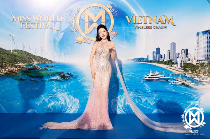 Á hậu Lê Phương Khánh Như chọn váy dạ hội tông hồng nhạt phủ chi tiết bắt sáng. Thiết kế ôm dáng, đi cùng phần tà dài từ vai xuống sàn. Cô buộc nửa tóc, lựa chọn lối trang điểm nhẹ và trang sức nhỏ.