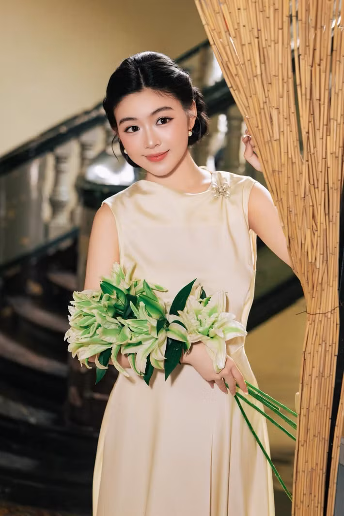 Diện váy lụa màu kem, Lọ Lem hướng đến phong cách cổ điển với phom dáng tối giản, điểm cài áo nhỏ ở vai. Cô búi tóc thấp, đeo khuyên tai ngọc trai, trang điểm nhẹ. (Ảnh: FB Mai Thảo Linh)