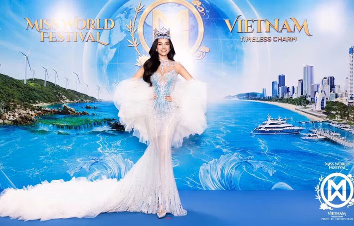 Chung kết Miss World 2026 - Hoa hậu Thế giới 2026 quy tụ dàn mỹ nhân đông đảo trên thảm xanh sự kiện. Đương kim Hoa hậu Thế giới Opal Suchata diện váy trắng bạc đính kết, phom đuôi cá ôm sát. Phần voan xếp lớp tạo khối lớn ở hai bên cánh tay, trong khi đuôi váy kéo dài trên thảm xanh. Cô đội vương miện và kết hợp bộ trang sức nổi bật.