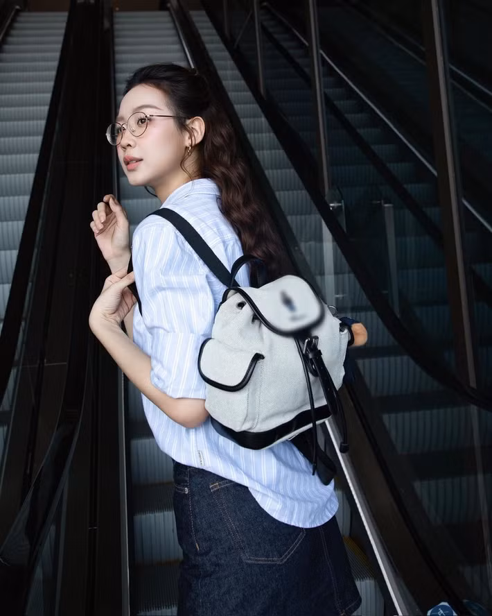 Phụ kiện kính gọng mảnh và túi xách mini tông trắng, vừa tạo điểm nhấn tinh tế, vừa giữ sự hài hòa cho trang phục.